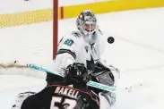  ?? Jae C. Hong / Associated Press ?? Sharks goaltender Devan Dubnyk deflects the puck as Anaheim’s Rickard Rakell watches.