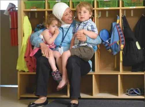  ??  ?? Azzah Abdulsamad is an ECE worker at Today’s Child on Upper Garth. She is seen here with two of her charges, Avery and Duncan. During Ramadan, Azzah fasts all day at work.