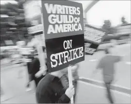  ?? Reed Saxon Associated Press ?? THE WGA came close to striking last week, only to reach a last-minute deal with studios. Above, WGA picketers outside Sony Pictures in Culver City in 2007.
