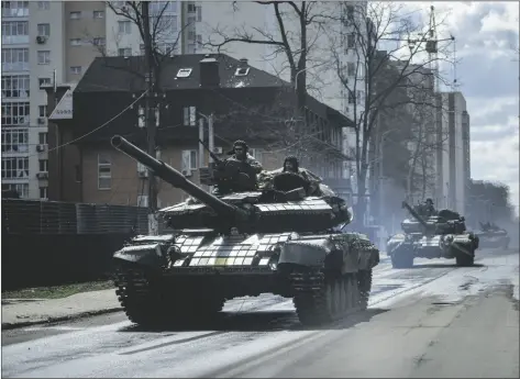  ?? EVGENIY MALOLETKA/AP ?? Ukrainian tanks move in a street in Irpin, in the outskirts of Kyiv, Ukraine, on Monday.