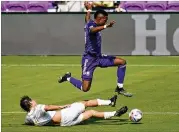  ?? JOHN RAOUX/AP ?? Orlando City midfielder Andres Perea moves the ball as he leaps over Atlanta United midfielder Santiago Sosa on Saturday in Orlando, Florida.