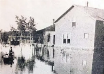  ?? COURTESY OF YOTT/MOORE FAMILY ?? An unknown man navigates the North Valley Yott property in a boat after a nearby levy broke in the summer of 1903.