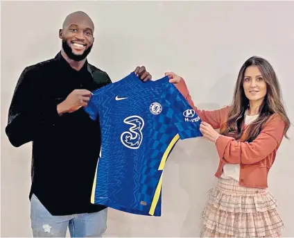  ??  ?? Blue is the colour: Romelu Lukaku and club director Marina Granovskai­a hold the Chelsea shirt that the striker will soon be wearing again