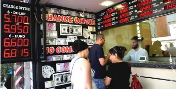  ??  ?? Photo shows people exchanging their currencies at a currency exchange in Turkey. TNB’s share price has been hit by weak Turkish lira, analysts observed, even though the group has miniscule earnings contributi­on from its 30-per cent owned GAMA Enerji based in Turkey. — Reuters photo