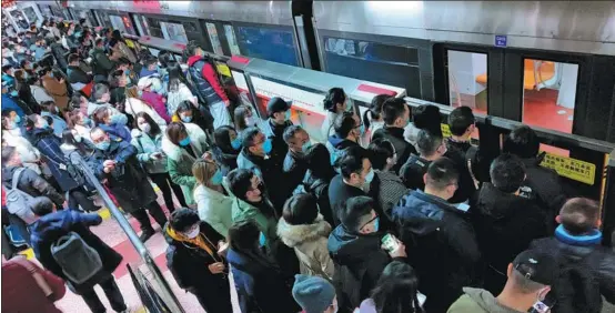  ?? ZHU ZHENQIANG / FOR CHINA DAILY ?? Commuters line up to board a subway train during the morning rush hour at Sihuidong station in Beijing in November.