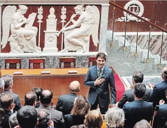  ?? FRANCOIS MORI THE ASSOCIATED PRESS ?? Canadian Prime Minister Justin Trudeau acknowledg­es applause from lawmkers as he arrives at the French National Assembly in Paris, France, Tuesday, as part of his two-day official visit to France.