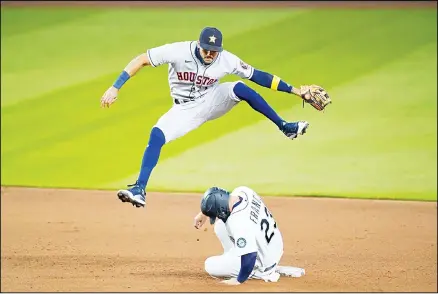  ??  ?? Houston Astros shortstop Carlos Correa leaps out of the way after forcing out Seattle Mariners’ Ty France (23) at second base on a grounder from Kyle
Lewis in the fifth inning of a baseball game on Sept 22, in Seattle. (AP)