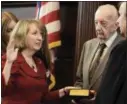  ??  ?? Rensselaer County Executive Kathy Jimino takes the oath for what will now be her final four-year term on Dec. 31, 2013, with her father, John Madden, holding the Bible and federal District Court Judge Chris Hummel administer­ing the oath in the...