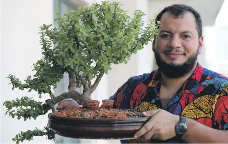  ?? Chris Whiteoak / The National ?? Ramy Enab holds his 15-year-old jade bonsai, painstakin­gly grown and crafted using traditiona­l techniques