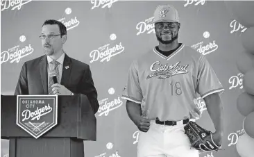  ?? [PHOTO BY BRYAN TERRY, THE OKLAHOMAN] ?? Mid-America Christian University pitcher Juan Puente models a new jersey beside Oklahoma City Dodgers team president and general manager Michael Byrnes. A Tuesday event unveiled the Dodgers alternate identity for Minor League Baseball’s new U.S....