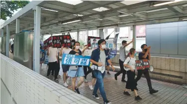  ?? (Lam Yik/Reuters) ?? PROTESTERS MARCH on a footbridge yesterday to campaign for the primary election aimed at selecting democracy candidates for the September election in Hong Kong.