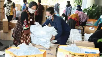  ?? FRIZAL/JAWA POS ?? TERIMA DONASI: Wali Kota Surabaya Tri Rismaharin­i menerima bantuan baju hazmat, masker, dan jenis barang lain. Bantuan tersebut lantas didistribu­sikan ke berbagai rumah sakit di Surabaya.