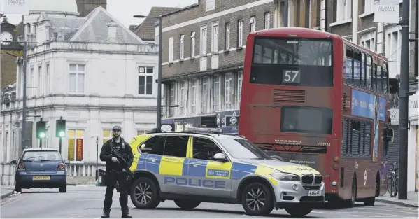  ??  ?? An officer stands guard near the scene where Sudesh Amman was shot and killed by armed police after stabbing two people in Streatham yesterday