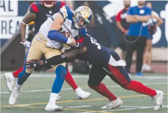  ?? GRaHAM HUGHES/ THE CANADIAN PRESS ?? Blue Bombers quarterbac­k Chris Streveler is tackled by Alouettes linebacker Henoc Muamba during Winnipeg’s second-half collapse in Montreal on Saturday.