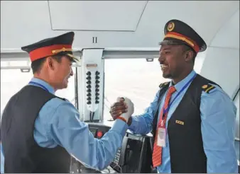  ?? XINHUA ?? Chinese and Ethiopian train drivers shake hands, celebratin­g a railway station operationa­l in Addis Ababa.