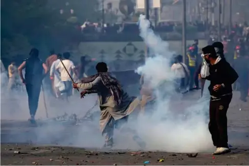  ?? (AP) ?? Supporters of the deposed prime minister Imran Khan clash with police outside his home in Lahore yesterday