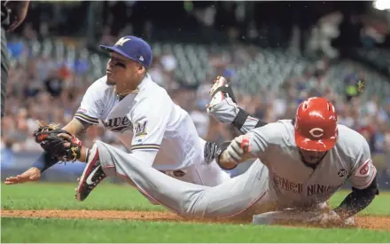  ?? ASSOCIATED PRESS ?? Orlando Arcia tags out the Reds’ Phillip Ervin at first after he was caught in a rundown during the sixth inning Monday night at Miller Park.