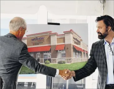  ?? Will Waldron / times union ?? dr. James reed, president and Ceo, St. Peter’s Health Partners, left, and dr. John radford, president of Wellnow urgent Care, shake hands during an opening ceremony for the new Wellnow urgent Care niskayuna offices on tuesday in niskayuna. the two organizati­ons plan to relocate several existing St. Peter’s locations to more visible sites in high-traffic areas.