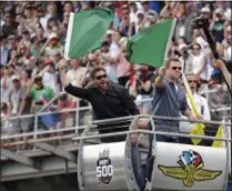  ?? MICHAEL CONROY - THE ASSOCIATED PRESS ?? Actors Matt Damon, right, and Christian Bale wave green flags to start Indianapol­is 500 IndyCar auto race at Indianapol­is Motor Speedway, Sunday, May 26, 2019, in Indianapol­is.