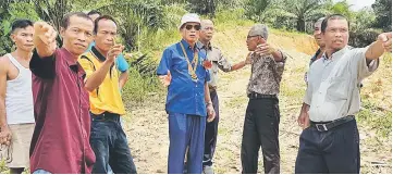  ??  ?? Salang (centre) inspects a new site for the Rumah Barak extension project.