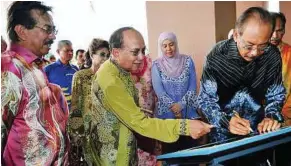  ??  ?? Official opening: Juhar signing a plaque at the ministry’s new integrated complex in Kota Kinabalu yesterday. With him are Dr Rais and Sabah Chief Minister Datuk Musa Aman (left). — Bernama