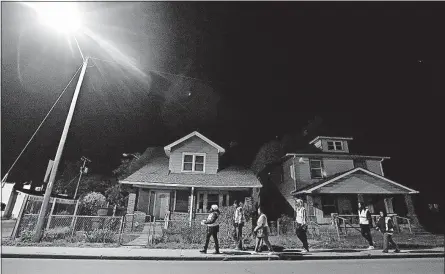  ?? [DARRON CUMMINGS/THE ASSOCIATED PRESS PHOTOS] ?? Members of the Ten Point Coalition walk through a problem neighborho­od in Indianapol­is. The coalition tries to get out and about in areas where there is violence, in an effort to reduce homicides through direct contact with the residents.