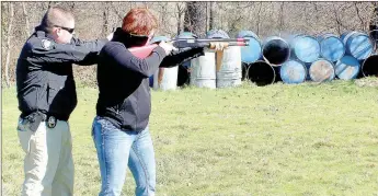  ?? Keith Bryant/The Weekly Vista ?? Officer Blake Hughes, left, stands ready with a firearm to provide lethal force, if necessary, while officer Janice Wilson fires a less-lethal round through one of the department's less-lethal designated shotguns.