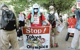  ?? David Mareuil Anadolu Agency ?? HAVING THE Olympics during the COVID-19 pandemic has generated protests in Japan, including this one in Tokyo a few hours before the opening ceremony.