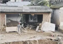  ??  ?? 0 A man surveys the damage after returning to Mocoa