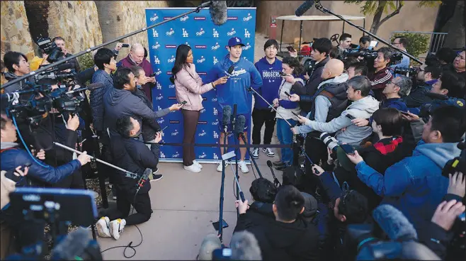 ?? CAROLYN KASTER / ASSOCIATED PRESS ?? Los Angeles’ Shohei Ohtani, with interprete­r Ippei Mizuhara, right, speaks to members of the media Feb. 9 at Camelback Ranch in Phoenix on the first day of spring training baseball workouts for the Dodgers.