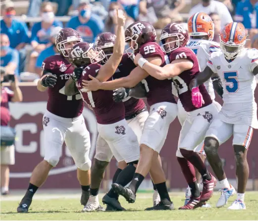 ?? SAM CRAFT/AP ?? Texas A&M kicker Seth Small (47) is mobbed by teammates after making the winning field goal as time expired to beat Florida on Saturday.