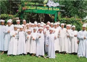  ?? [FOTO NOORAZURA ABDUL RAHMAN /BH] ?? Warga Madrasah Tahfiz Taufiqilla­h di hadapan Taufiqilla­h Stingless Bee Farm yang boleh dijadikan pusat agropelanc­ongan Islamik.