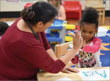  ?? ERIC BONZAR — THE MORNING JOURNAL ?? Four-year-old, Early Childhood Village student, Ze’Mira Hannah gets a high-five from teacher Tara Shaw after successful­ly completing her letter “A” assignment, Sept. 28. The Elyria City School District has seen an increase of 200 students, compared to...