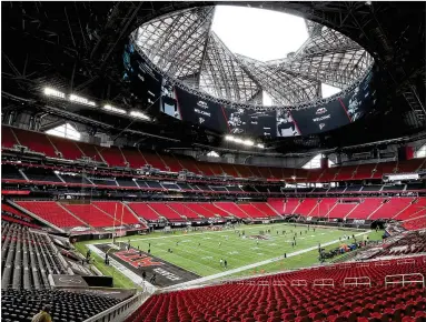  ?? CURTIS COMPTON / CURTIS.COMPTON@AJC.COM ?? Mercedes-Benz Stadium sits empty of fans but with the roof open Sunday. The bright sunlight flooded the field and illuminate­d the emptiness of the place. Mascot Freddie the Falcon worked the empty aisles.