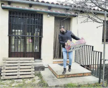  ??  ?? Santos, sacando una caja de la vivienda.