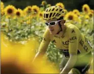  ?? PETER DEJONG — THE ASSOCIATED PRESS ?? Britain’s Geraint Thomas, wearing the overall leader’s yellow jersey, passes fields of sunflowers during the eighteenth stage of the Tour de France cycling race over 171 kilometers (106.3 miles) with start in Trie-sur-Baise and finish in Pau, France, Thursday.