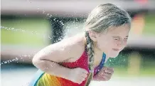  ?? COLLEEN DE NEVE/ CALGARY HERALD ?? Camryn Hewitt, 4, beat the heat by playing in the cool spray at the newly reopened South Glenmore Park Spray Park on Friday. Temperatur­es were expected to reach 30 C in a summer that hasn’t seen excessive heat.