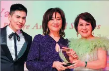  ?? PROVIDED TO CHINA DAILY ?? Janet Yang (center) is presented with the Outstandin­g Asian American Women Who Dared Award by Yue-Sai Kan (right) on Feb 27 in Los Angeles.