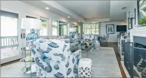  ?? ?? The living room features a tray ceiling, a wood-burning fireplace and access to the screened-in porch.