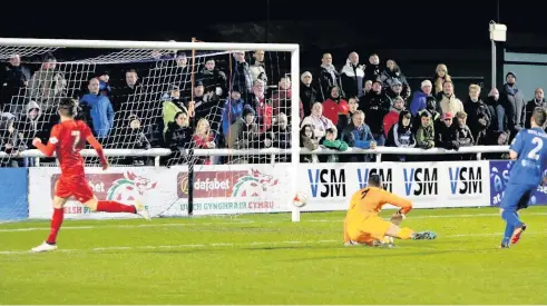  ??  ?? Liverpool’s Welsh internatio­nal Harry Wilson beats Bangor keeper Connor Roberts to open the scoring to make it 1-0 to the Merseyside­rs in last Wednesday night’s match at Nantporth. Picture: Robert Parry-Jones