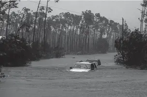  ?? RAMON ESPINOSA/ASSOCIATED PRESS ?? Cars are abandoned during Hurricane Dorian Tuesday in Freeport, Bahamas. Dorian is beginning to inch northwestw­ard after being stationary over the Bahamas, where its relentless winds have caused catastroph­ic damage and flooding.