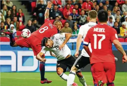  ??  ?? Augen zu und durch: Emre Can im Duell mit Chiles Arturo Vidal. Foto: Christian Charisius/dpa