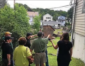  ?? RECORD FILE PHOTO ?? Elected officials look at some of the damage a backyard on Main Street in Hoosick Falls suffered from severe flood damage.