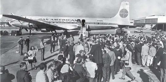  ?? The Historical Museum of Southern Florida ?? Cuban refugees aboard the first Freedom Flight arrive at Miami Internatio­nal Airport on Dec. 1, 1965, with a sea of relatives and reporters awaiting the historic flight.