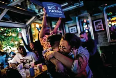  ?? New York Times file photo ?? Laura Rodríguez and Ariana Lyons embrace in Atlanta as they watch Presidente­lect Joe Biden give his victory speech on TV this month. Biden won the election in part because of Black voters in Georgia, Michigan, Wisconsin and Pennsylvan­ia, many of them in cities such as Atlanta, Detroit and Philadelph­ia where he received a significan­t share of their support.