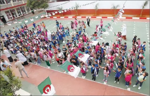  ?? (File Photo/AP) ?? Schoolchil­dren wait in line Sept. 19 in a school courtyard in the Ben Omar district of Algiers, Algeria.