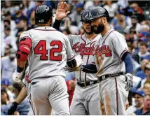  ?? DAVID BANKS / GETTY IMAGES ?? Jose Bautista (left)is greetedby Tyler Flowers and Nick Markakis after hitting a three-run homer against the Cubs in the fifth inning Monday. All players wore 42 in honor of Jackie Robinson.