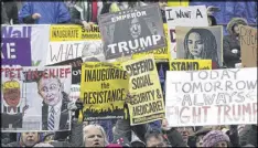  ?? KEVIN DIETSCH / POOL / GETTY IMAGES ?? Protesters demonstrat­e as President Donald Trump and first lady Melania Trump walk in the inaugural parade after being sworn in at the 58th Presidenti­al Inaugurati­on Thursday.