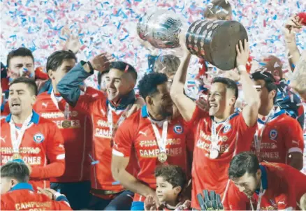  ??  ?? Entre sus compañeros, el chileno Alexis Sánchez levanta el trofeo que les acredita como vencedores de la Copa América Chile 2015, tras la final disputada frente a Argentina en el Estadio Nacional de Santiago.