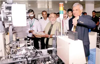  ??  ?? Prime Minister Ranil Wickremesi­nghe inspects machinery at the new Flexiprint factory at Flinth Commercial Park in Ranmuthuga­la along with Flexiprint Managing Director Sathis Abeywickra­ma PIC BY PRADEEP PATHIRANA